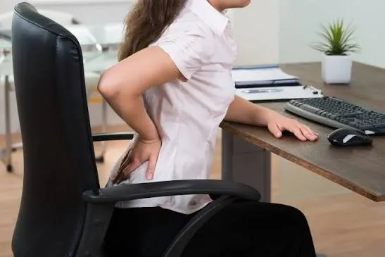Person performing gentle shoulder mobility at desk